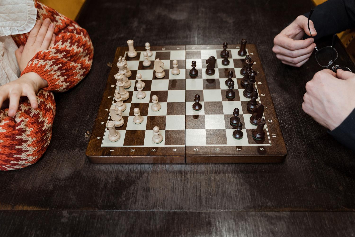 Jugador de ajedrez analizando la posición del tablero con concentración, ilustrando la toma de decisiones estratégicas. Jugador de ajedrez analizando la posición del tablero con concentración, ilustrando la toma de decisiones estratégicas.