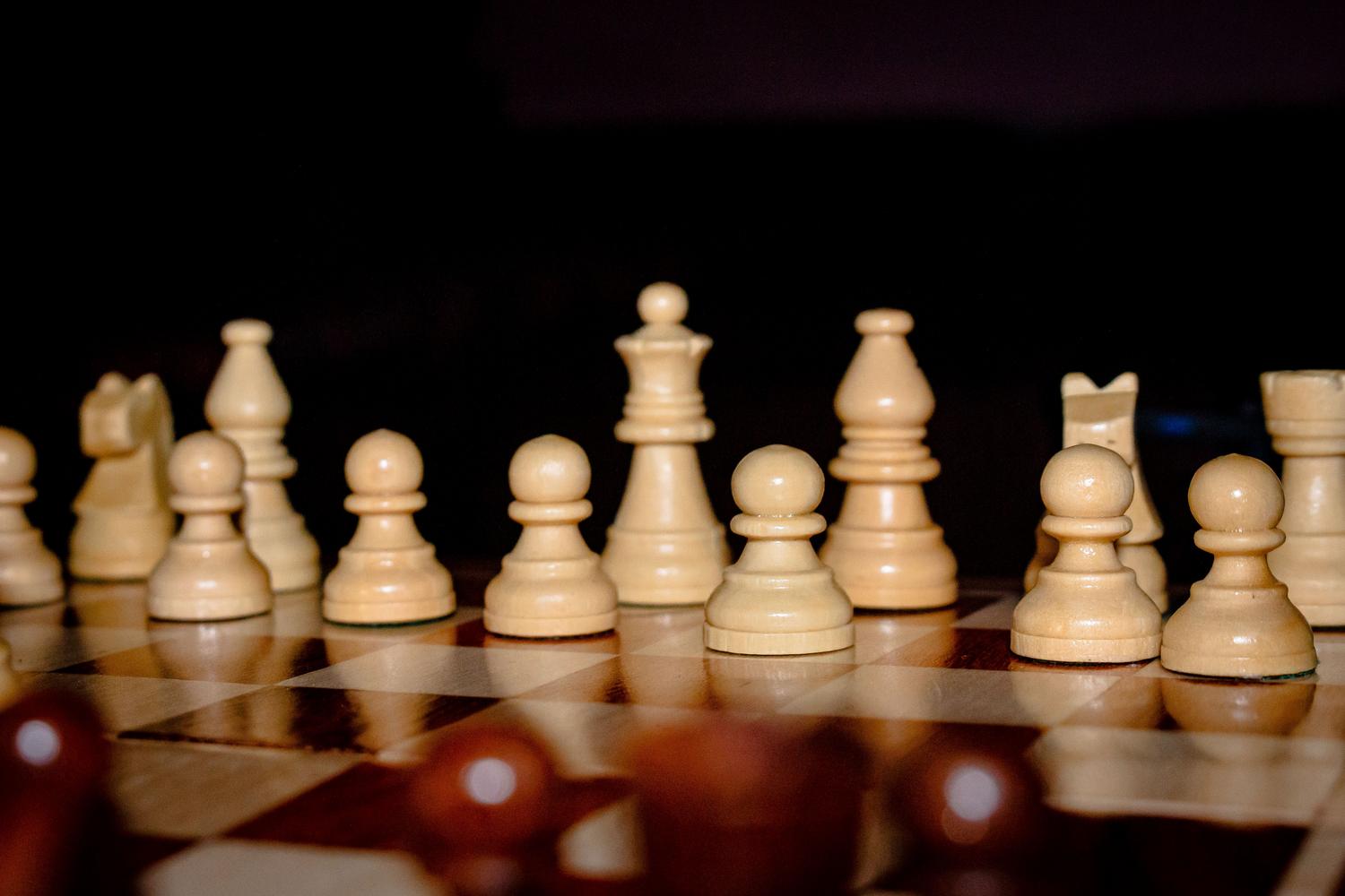 Disposición estratégica de piezas de ajedrez con profundidad de campo, simbolizando la planificación y el control del centro. Disposición estratégica de piezas de ajedrez con profundidad de campo, simbolizando la planificación y el control del centro.