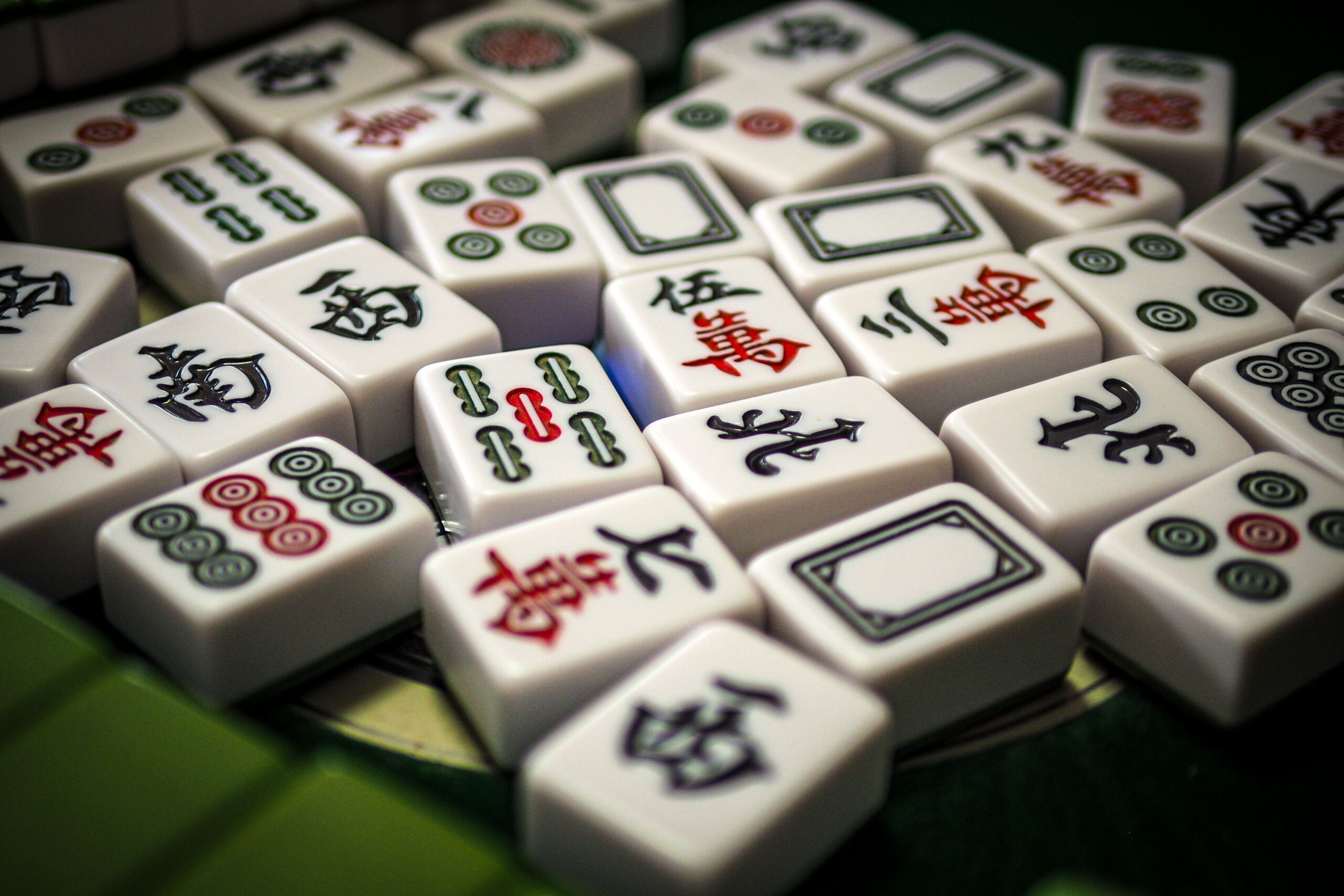 Primer plano detallado de fichas de Mahjong mostrando los caracteres chinos tradicionales, los bambúes y los círculos. Primer plano detallado de fichas de Mahjong mostrando los caracteres chinos tradicionales, los bambúes y los círculos.