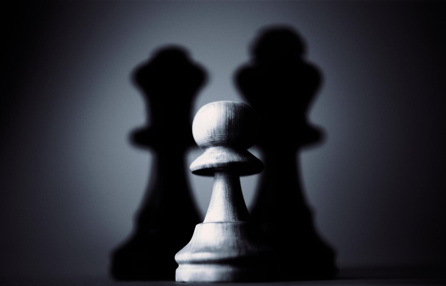Imagen minimalista en blanco y negro de un peón blanco en primer plano, evocando la importancia de los movimientos iniciales y la estructura de peones. Imagen minimalista en blanco y negro de un peón blanco en primer plano, evocando la importancia de los movimientos iniciales y la estructura de peones.