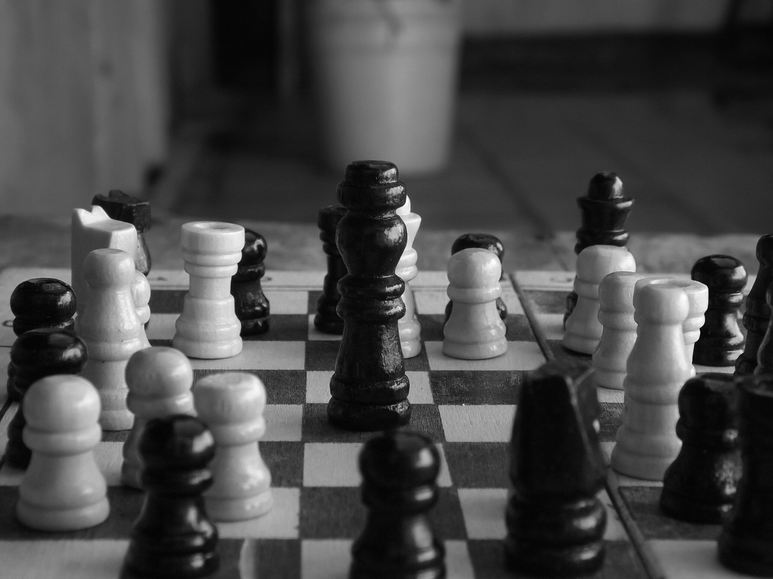 Fotografía artística en blanco y negro de una reina negra dominante en el tablero, resaltando la naturaleza clásica y seria de la estrategia ajedrecística. Fotografía artística en blanco y negro de una reina negra dominante en el tablero, resaltando la naturaleza clásica y seria de la estrategia ajedrecística.