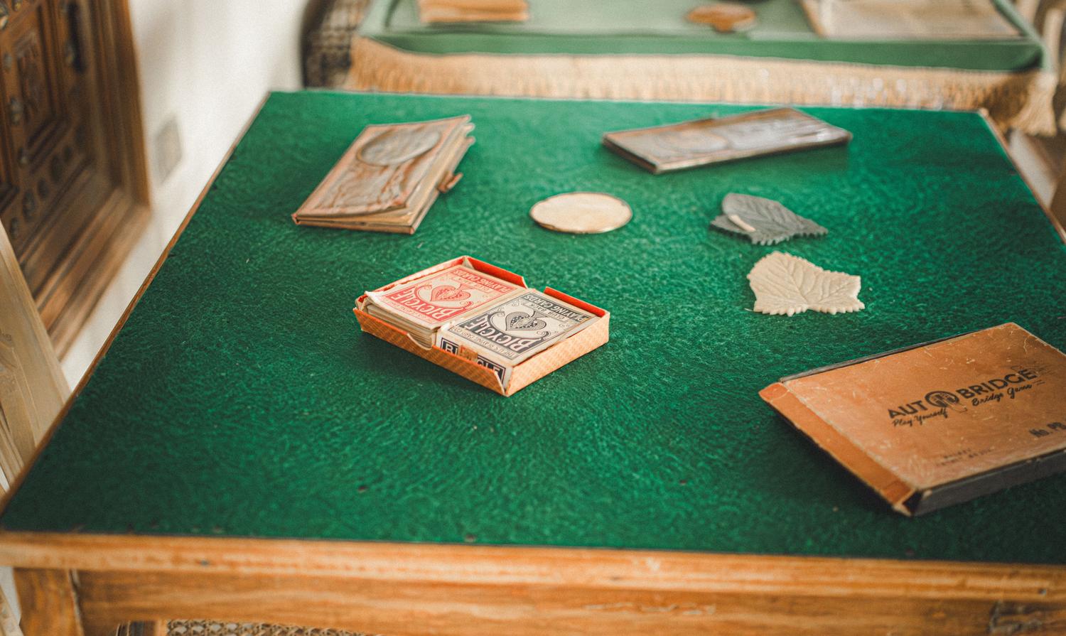 Configuración vintage de un juego de Bridge con mazos de cartas y tablero sobre fieltro verde, evocando el ambiente clásico de los clubes. Configuración vintage de un juego de Bridge con mazos de cartas y tablero sobre fieltro verde, evocando el ambiente clásico de los clubes.