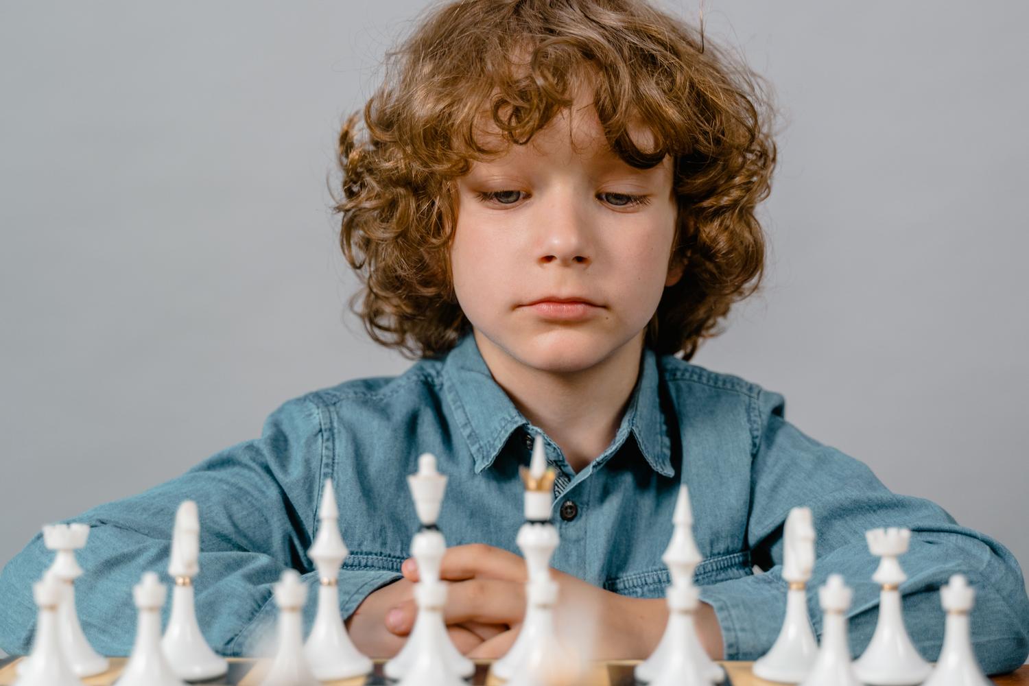 Niño concentrado analizando una jugada de ajedrez, representando el entrenamiento mental y la disciplina. Niño concentrado analizando una jugada de ajedrez, representando el entrenamiento mental y la disciplina.