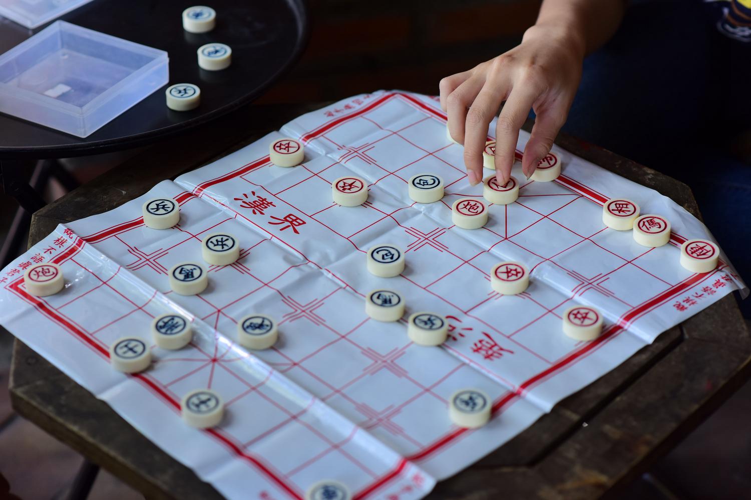 Primer plano de una mano moviendo una pieza de Xiangqi sobre el tablero. Primer plano de una mano moviendo una pieza de Xiangqi sobre el tablero.
