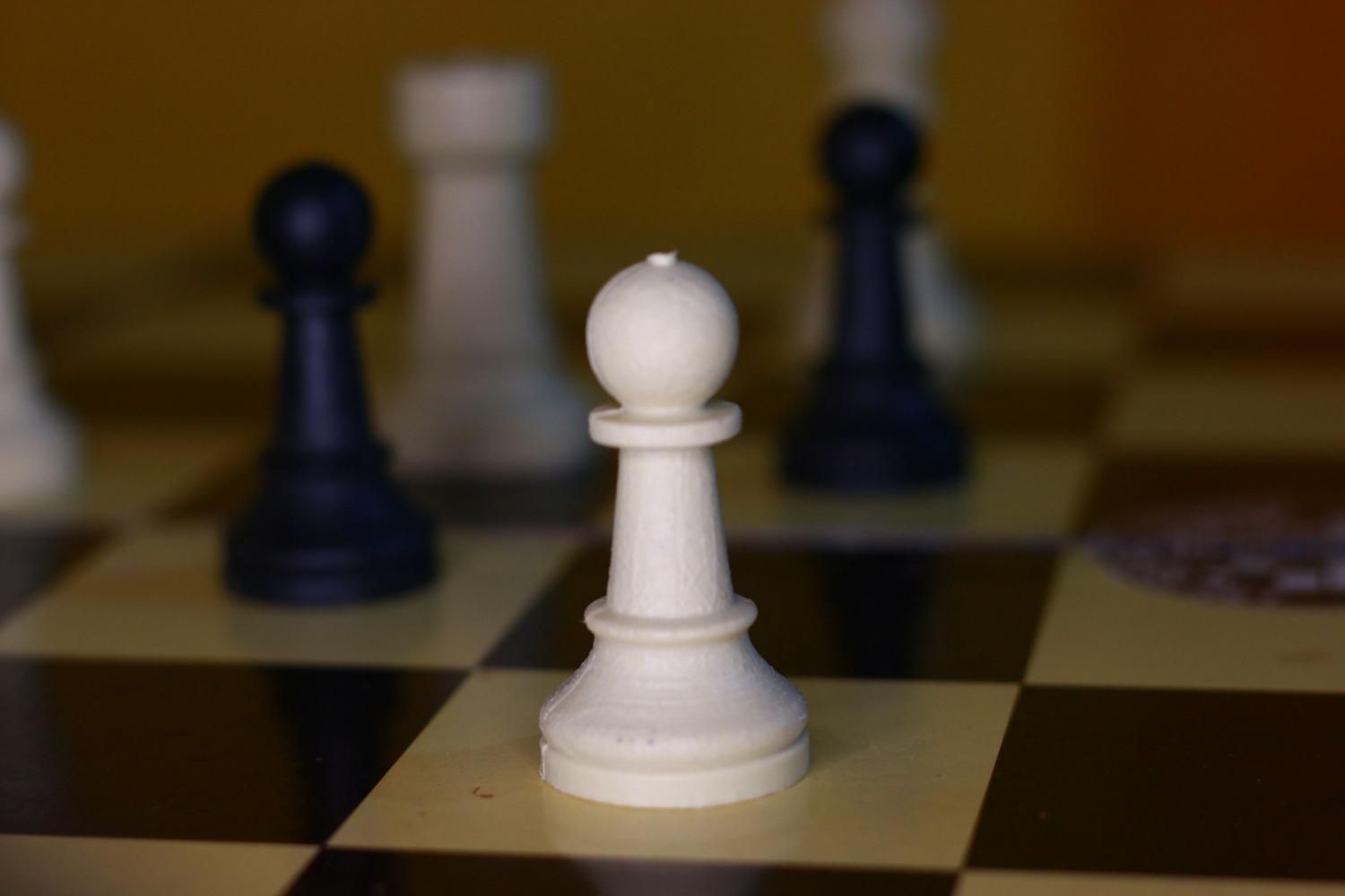 Peón blanco en primer plano sobre un tablero de ajedrez clásico, simbolizando el objetivo de coronación en la posición de Lucena. Peón blanco en primer plano sobre un tablero de ajedrez clásico, simbolizando el objetivo de coronación en la posición de Lucena.
