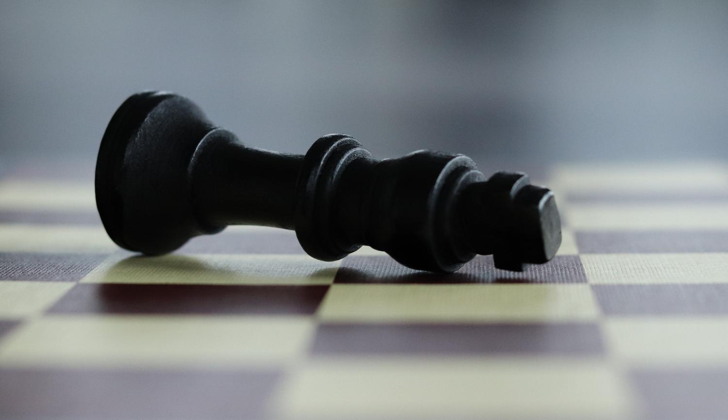 Pieza de ajedrez caída sobre el tablero con fondo desenfocado, simbolizando el error decisivo o la rendición final tras caer en una trampa de zugzwang. Pieza de ajedrez caída sobre el tablero con fondo desenfocado, simbolizando el error decisivo o la rendición final tras caer en una trampa de zugzwang.