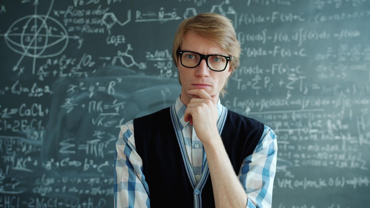 Profesor reflexionando ante una pizarra llena de ecuaciones, ilustrando la capacidad de análisis y evaluación de la información. Profesor reflexionando ante una pizarra llena de ecuaciones, ilustrando la capacidad de análisis y evaluación de la información.